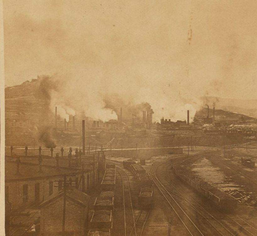 Stereograph of smelters pouring smoke at the base of Anaconda Hill, Butte